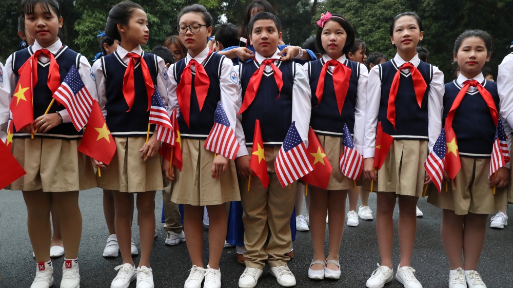 Students outside the Presidential Palace in Hanoi wait to greet Trump [Leah Millis/Reuters]