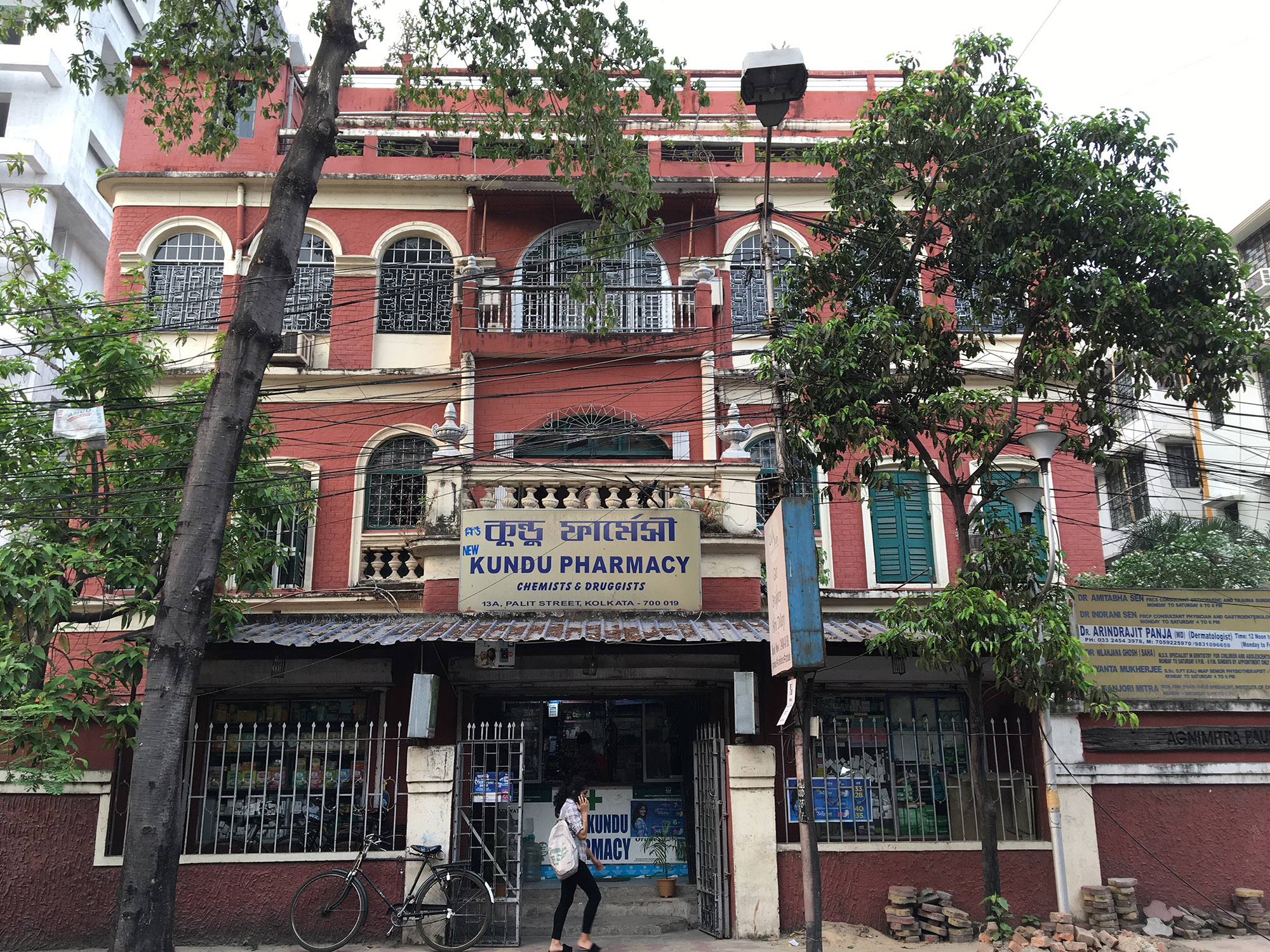 Owners of this residential building in south Kolkata have leased out the ground floor of their home to a pharmacy [Neha Banka/Al Jazeera]