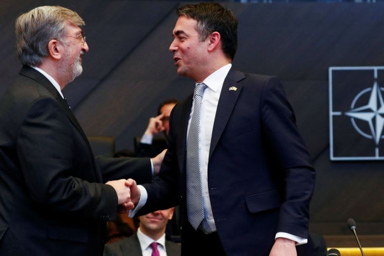 Greek Ambassador to NATO Spiros Lambridis shakes hands with Macedonian Foreign Minister Nikola Dimitrov