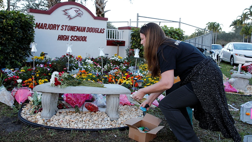 Bouquets are placed at a memorial on campus on the one-year anniversary of the shooting which claimed 17 lives at Marjory Stoneman Douglas High School in Parkland, Florid [Joe Skipper/Reuters] 