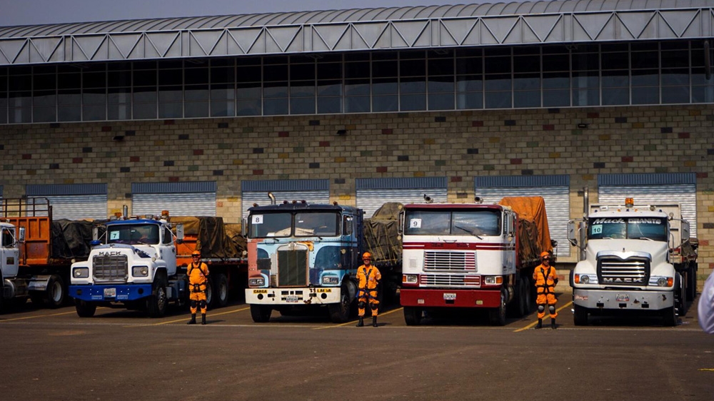 Trucks carrying humanitarian aid for Venezuela in the area of a warehouse [Mia Alberti/Al Jazeera]