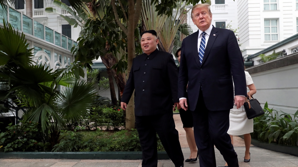 Kim and Trump walk in the garden of the Metropole hotel [Leah Millis/Reuters]