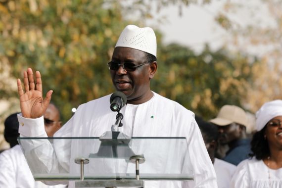 Senegal's President and a candidate for the upcoming presidential elections Macky Sall, speaks after casting his vote at a polling station as his wife Marem Faye Sall stands behind in Fatick