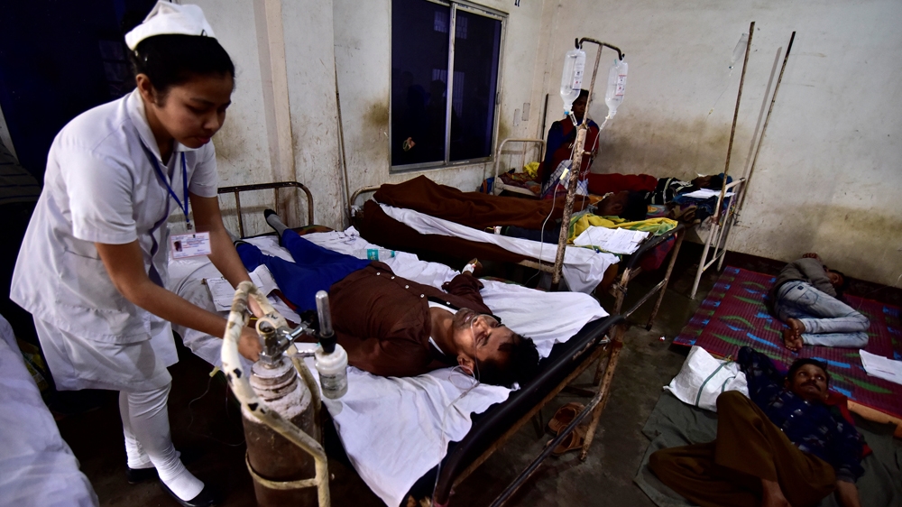A paramedic tends to a tea plantation worker, who consumed bootleg liquor, inside a government-run hospital in Golaghat [Anuwar Hazarika/Reuters]