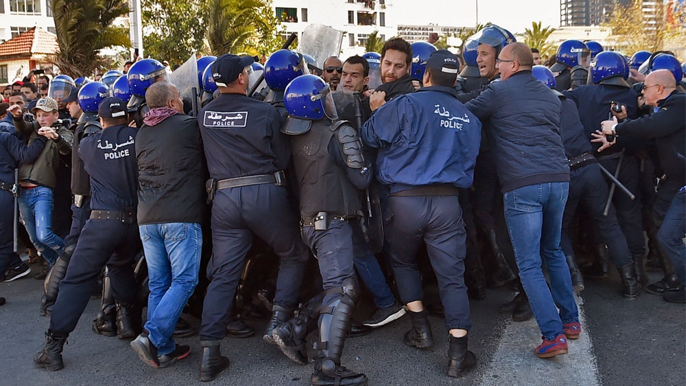 Algerian policemen push back protesters during a demonstration in Algiers [Ryad Kramdi/AFP]