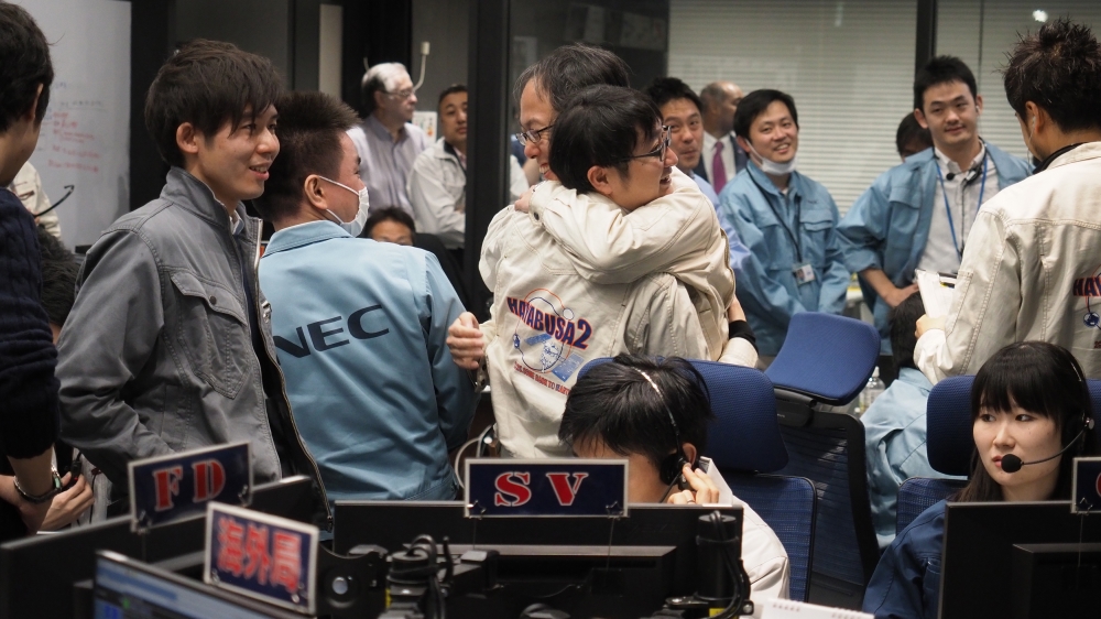 JAXA staff applauded as a signal sent from space indicated the Hayabusa2 spacecraft had touched down [ISAS/JAXA via AP]