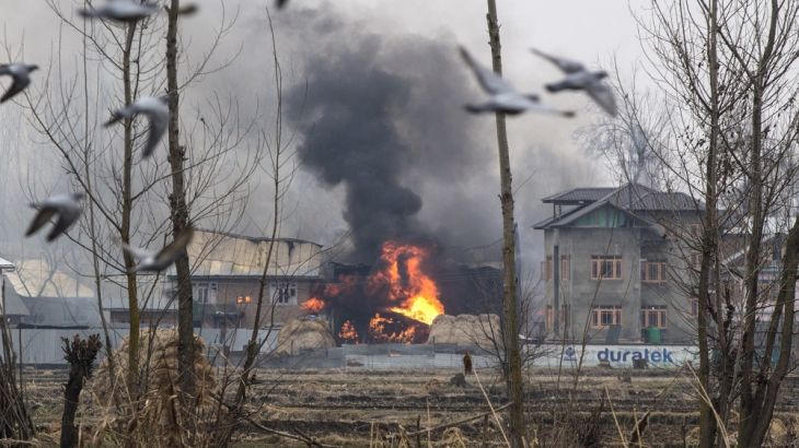 Flames and smoke billows from a residential building where militants are suspected to have taken refuge during a gun battle in Pulwama, south of Srinagar, Indian controlled Kashmir, Monday, Feb. 18, 2
