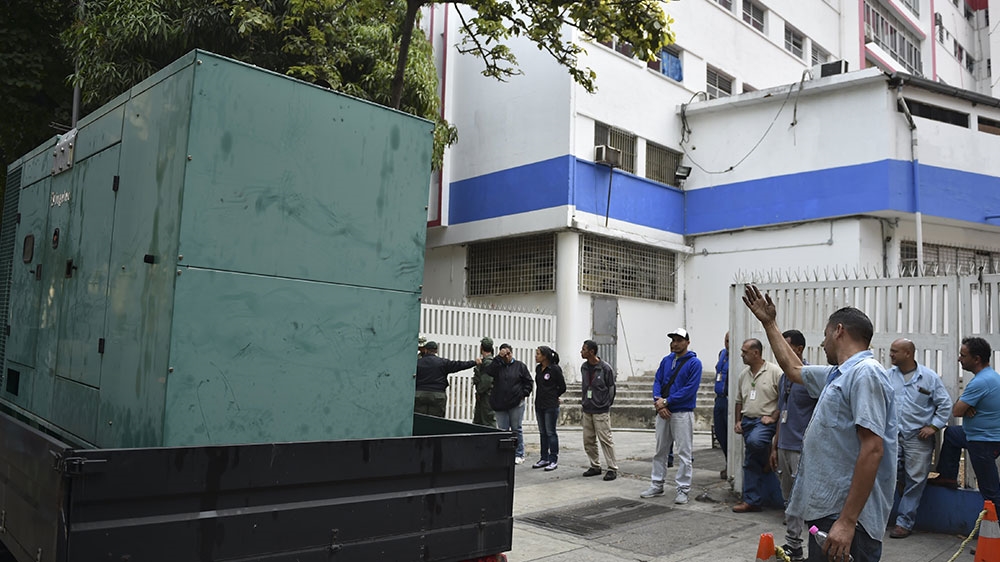 Workers of the state-run electricity company CORPOELEC arrive at the children's hospital with a generator during a power outage in Caracas  [Yuri Cortez/AFP] 