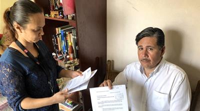 Indira Penne and her husband Sergio Rey keep letters and documents they've sent the authorities asking for resources and support to contain violence against women in their neighbourhood [Isabella Cota/Al Jazeera]