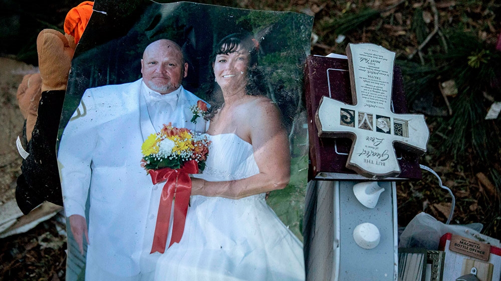 A wedding photo of Carol Dean and David Wayne Dean sits in a pile of personal items Carol Dean recovered while sifting through the debris after a tornado destroyed their home a day earlier killing her husband in Beauregard [David Goldman/AP Photo]