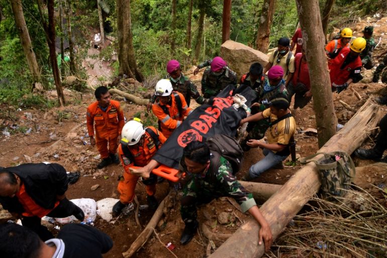Rescue workers carry a body bag containing a victim after the landslide of the illegal gold mine at Bolaang Mongondow Regency in North Sulawesi