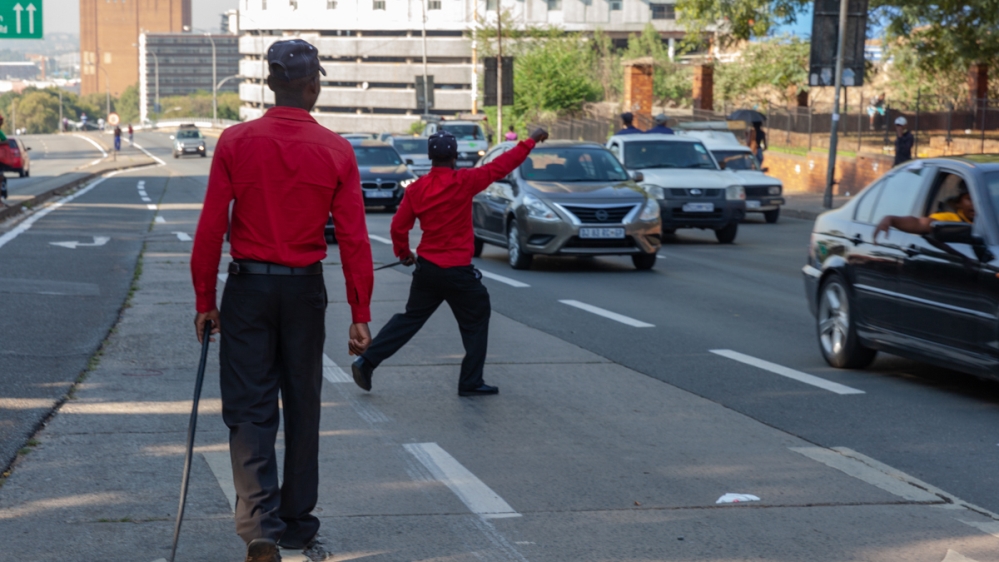 The safety wardens take an active role to keep the busy intersection crime-free [Tshego Mmahlatji/Al Jazeera]
