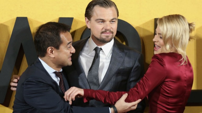 Leonardo DiCaprio and Margot Robbie pose with Riza Aziz, the stepson of then Malaysian prime minister Najib Razak. They are on the red carpet for Wolf of Wall Street, which was produced by Riza. 