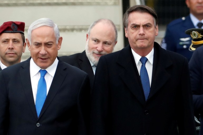 Brazilian President Jair Bolsonaro stands next to Israeli Prime Minister Benjamin Netanyahu during a welcoming ceremony upon his arrival in Israel