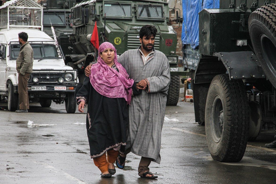 A young man taking away a frightened woman from an encounter site in Khudwani area of South Kashmir. Kashmir has witnessed unexpected increase in insurgency and encounters from past few years.