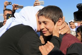 A relative kisses a Yazidi survivor boy following his release from Islamic State militants in Syria, in Duhok