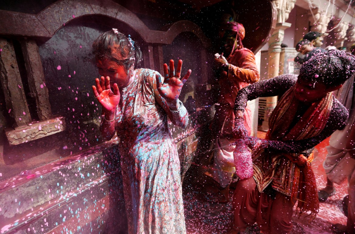 A boy sprays coloured water on a girl during religious religious festival of Holi inside a temple in Nandgaon village, in the state of Uttar Pradesh, India, March 16, 2019. REUTERS/Adnan Abidi