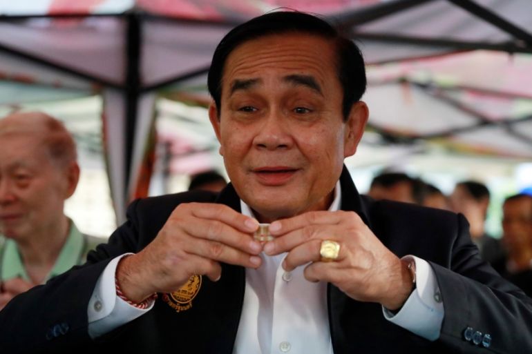 Thailand''s Prime Minister Prayut Chan-o-cha drinks tea with people who are exercising in Lumphini Park in Bangkok