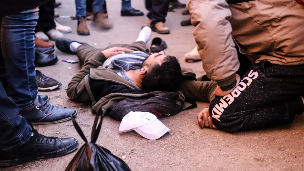 A young Palestinian man faints at Checkpoint 300 [Jaclynn Ashly/Al Jazeera] 