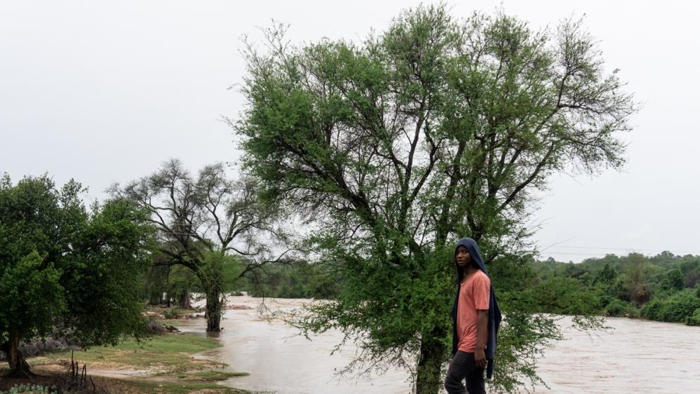 A man walks past the Devuli River in southeastern Zimbabwe where water levels have risen significantly [Tendai Marima/Al Jazeera]