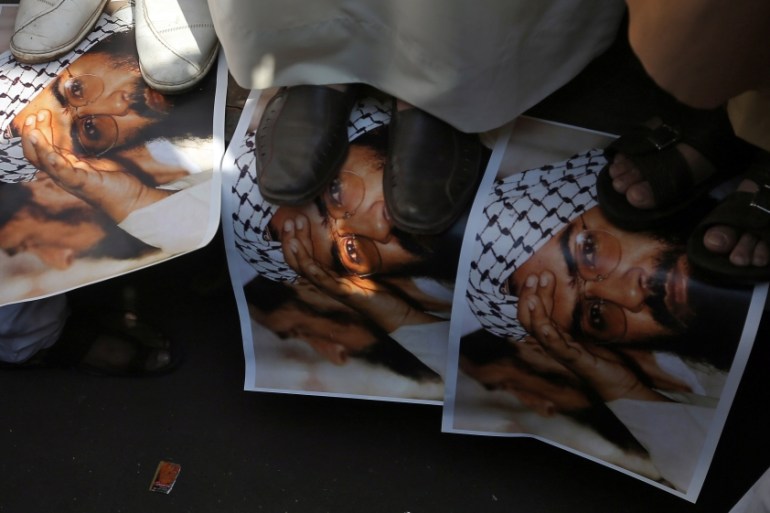 Demonstrators step on the posters of Maulana Masood Azhar, head of Pakistan-based militant group Jaish-e-Mohammad, during a protest in Mumbai