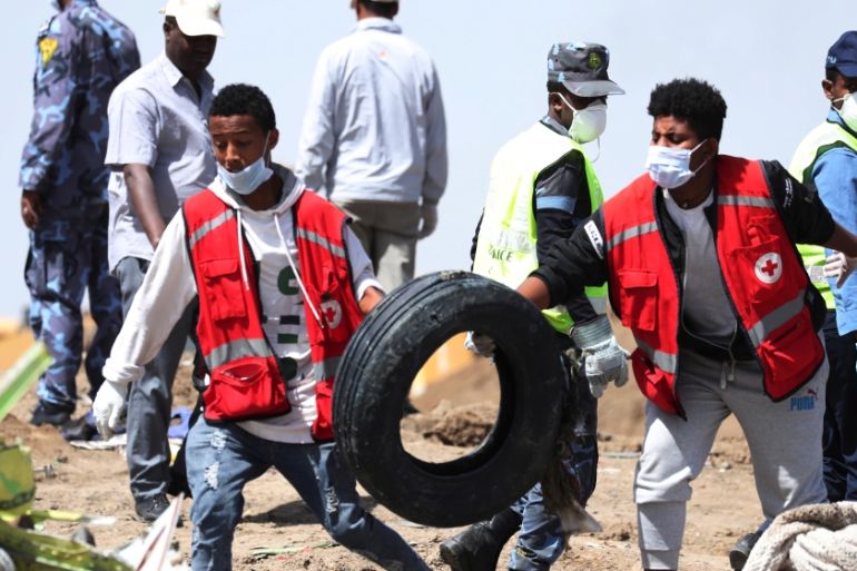 Search workers carry a tyre at the scene of the Ethiopian Airlines Flight ET 302 plane crash, near the town of Bishoftu