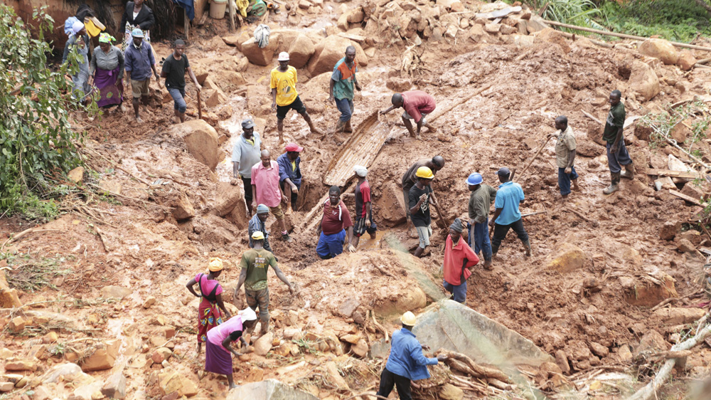 A Zimbabwean family dig for their son who got buried in the mud when Cyclone Idai struck [Tsvangirayi Mukwazhi/AP]