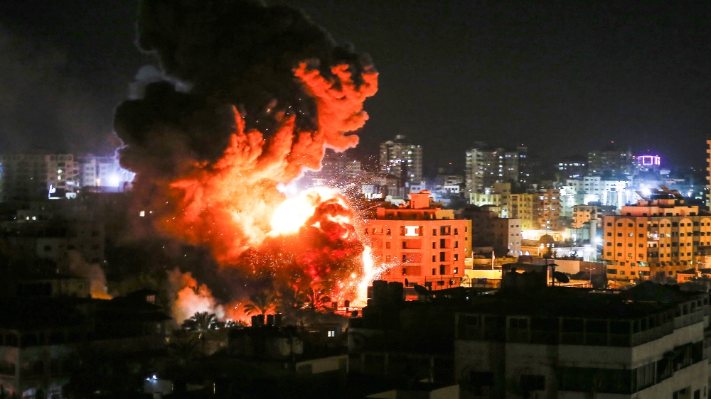 Flames and smoke are seen during an Israeli air raid in Gaza City [Mahmud Hams/AFP]