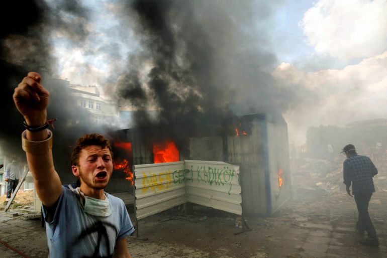An anti-government protester shouts for help to extinguish a burning container on Taksim square in Istanbul, Turkey, June 4, 2013. It was not clear why the container was on fire. REUTERS/Yannis Behrak