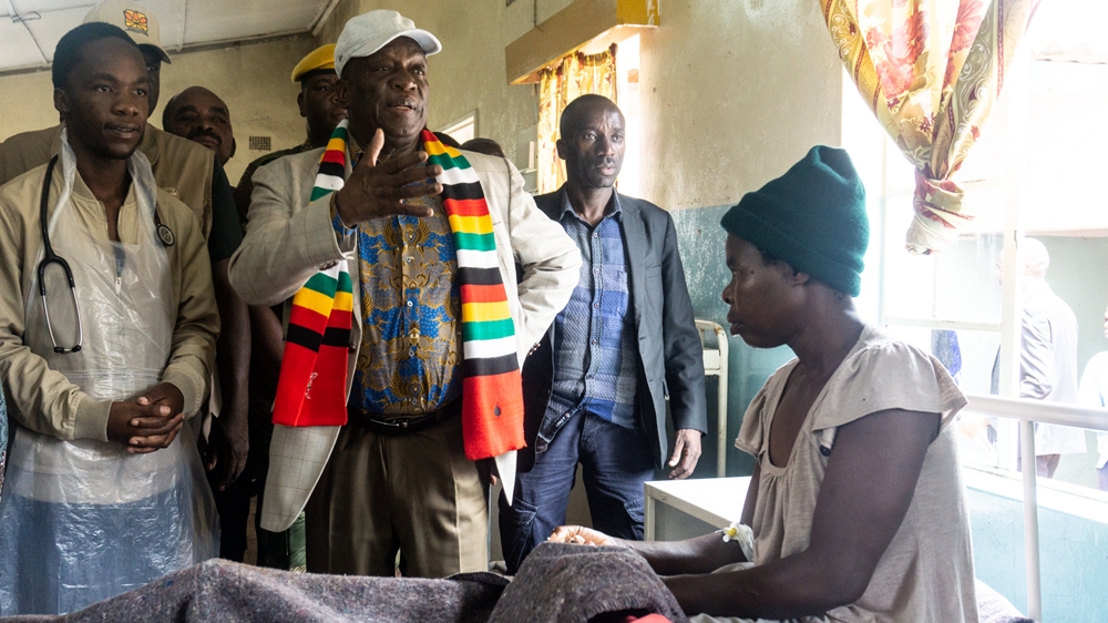 President Emmerson Mnangagwa and Lindo Sithole, left, a volunteer doctor visit a patient injured in the cyclone at Chimanimani Rural District Hospital on Wednesday [Tendai Marima/Al Jazeera]