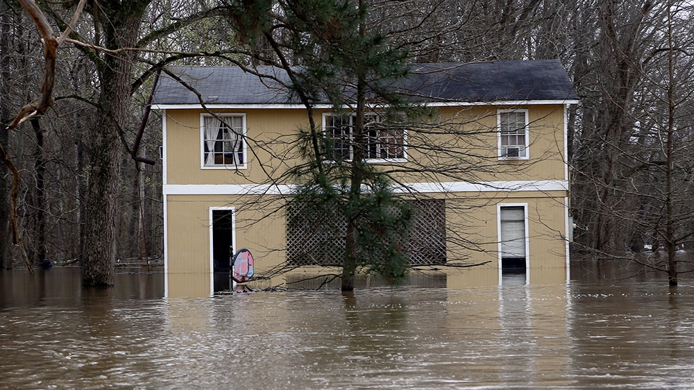 Yazoo River waters surround a home in the Chickasaw subdivision of Vicksburg, Mississippi [Rogelio V Solis/AP Photo]