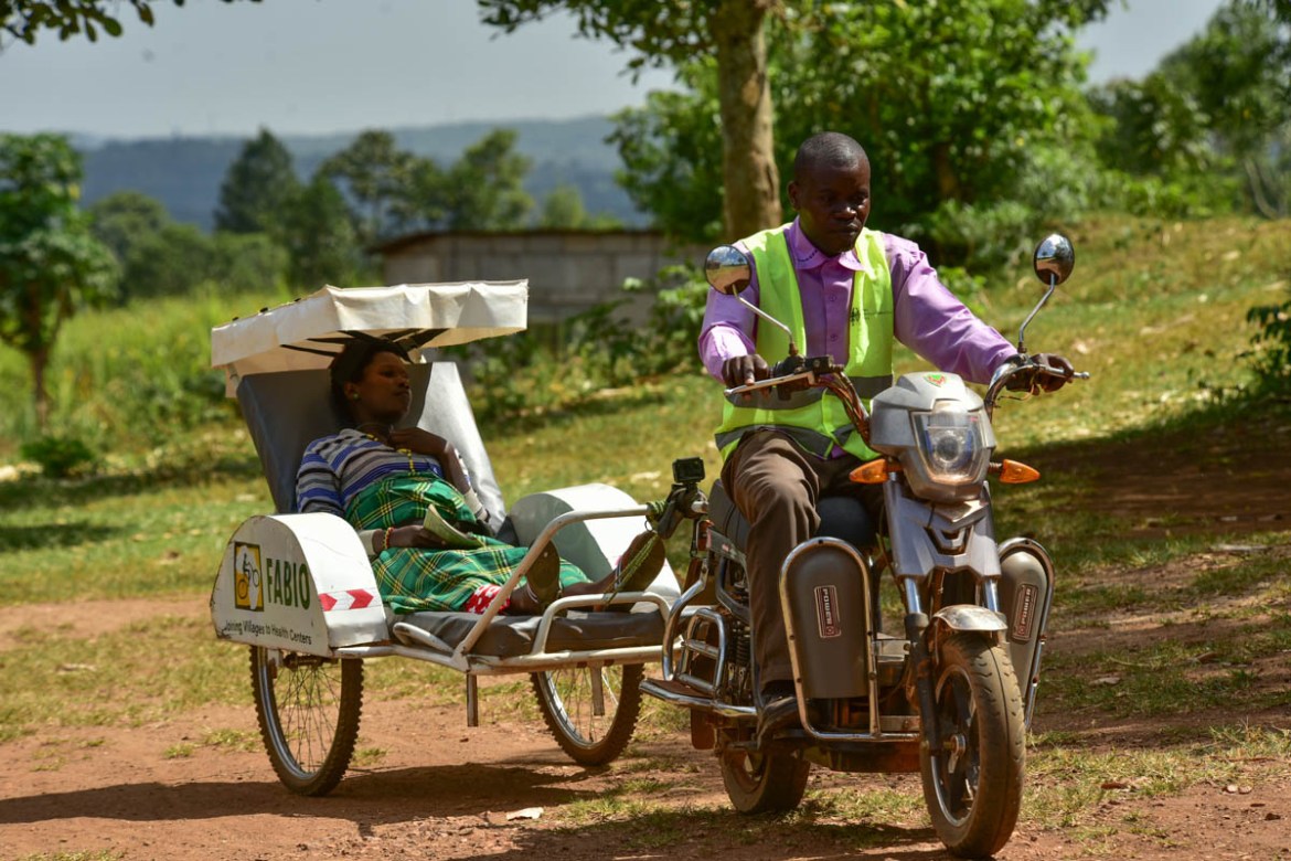 Paul Hamba a Village Health Team member in Budondo Sub County rides Namuswa Juliet a 7 months pregnant expectant mother on his ambulance carrier back to her home 5 kilometers away from the health cent