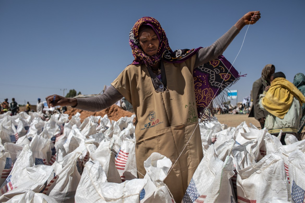 A worker opens bags of wheat at a distribution point in Hawzen district, in Misraqawi Zone, Tigray Region, Ethiopia, on February 6, 2019.