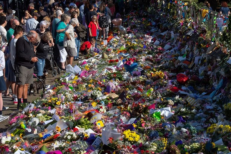 Floral tributes to those who were gunned down at the two mosques are seen against a wall bordering the Botanical Garden in Christchurch on March 19, 2019. - New Zealand Prime Minister Jacinda Ardern v