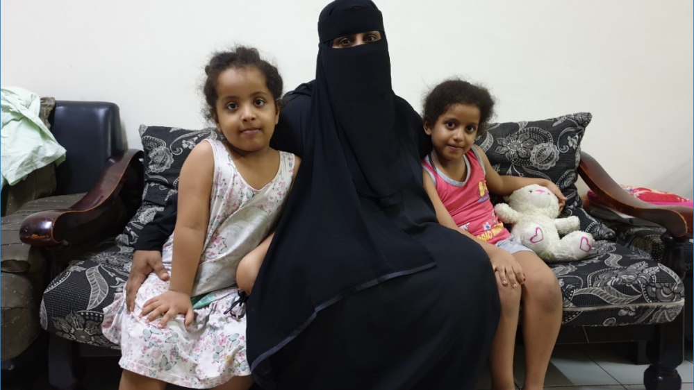Amira and her two young daughters in their flat in Kuala Lumpur [Al Jazeera]
