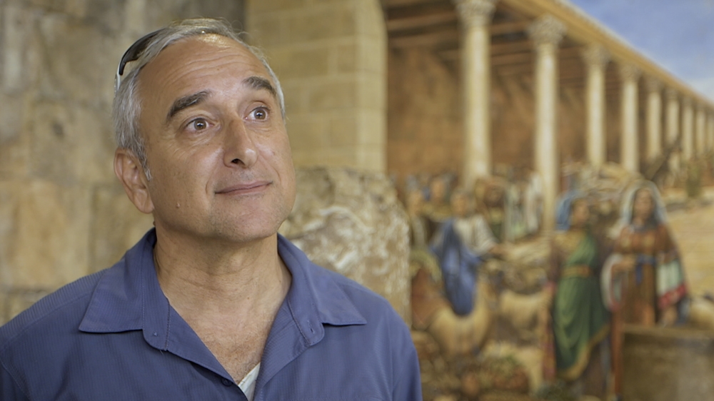 Daniel Luria standing in front of an old Roman mural, in an ancient corridor in the Old City [Al Jazeera]
