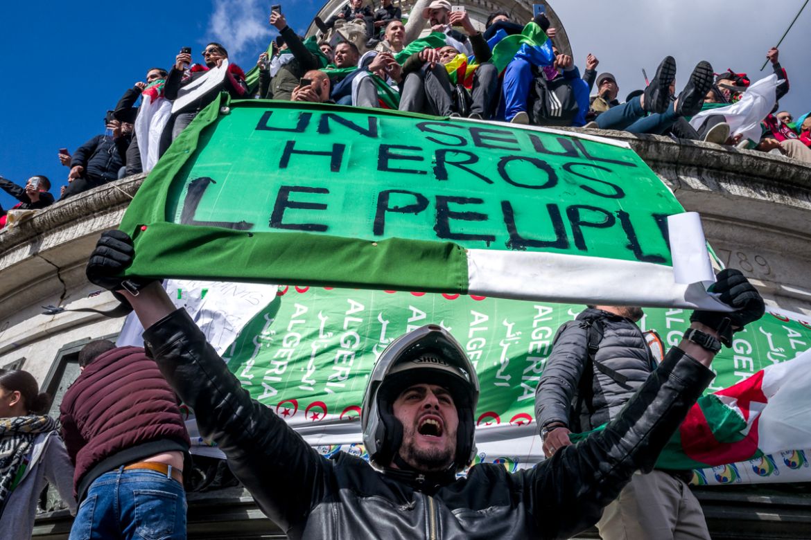 An Algerian protester shouts slogans holding a sign in support of the Algerian people during a demonstration against Algerian President Abdelaziz Bouteflika in Place de la RE`publique in Paris, France