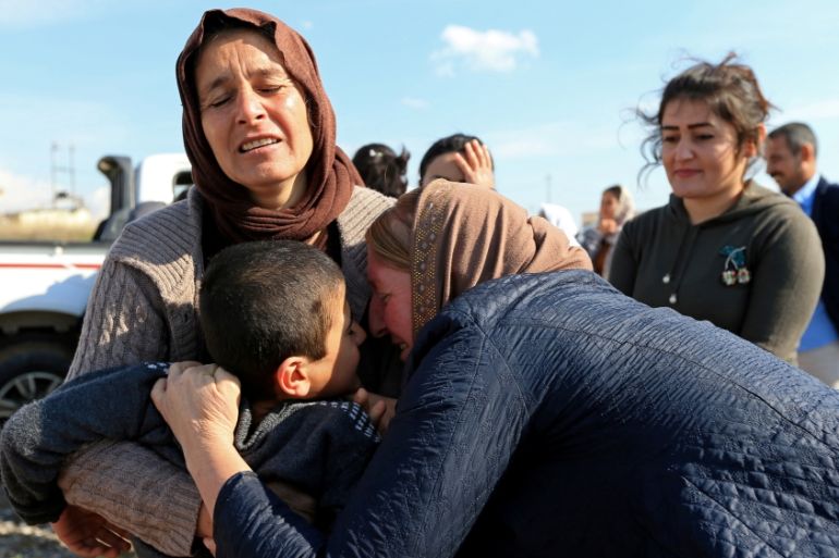 Relatives hug a Yazidi survivor boy following his release from Islamic State militants in Syria, in Duhok