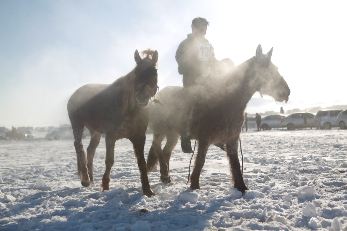Steam fills the air as heat emanates from horse and rider against the winter chill. [Davaanyam Delgerjargal/Al Jazeera]