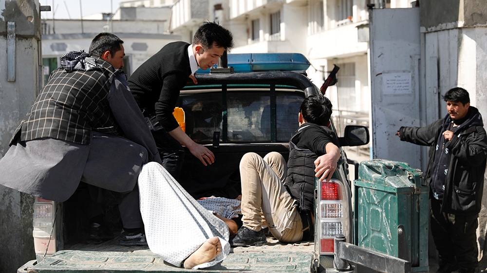 Men take an injured person to the hospital after attacks in Kabul [Mohammad Ismail/Reuters]