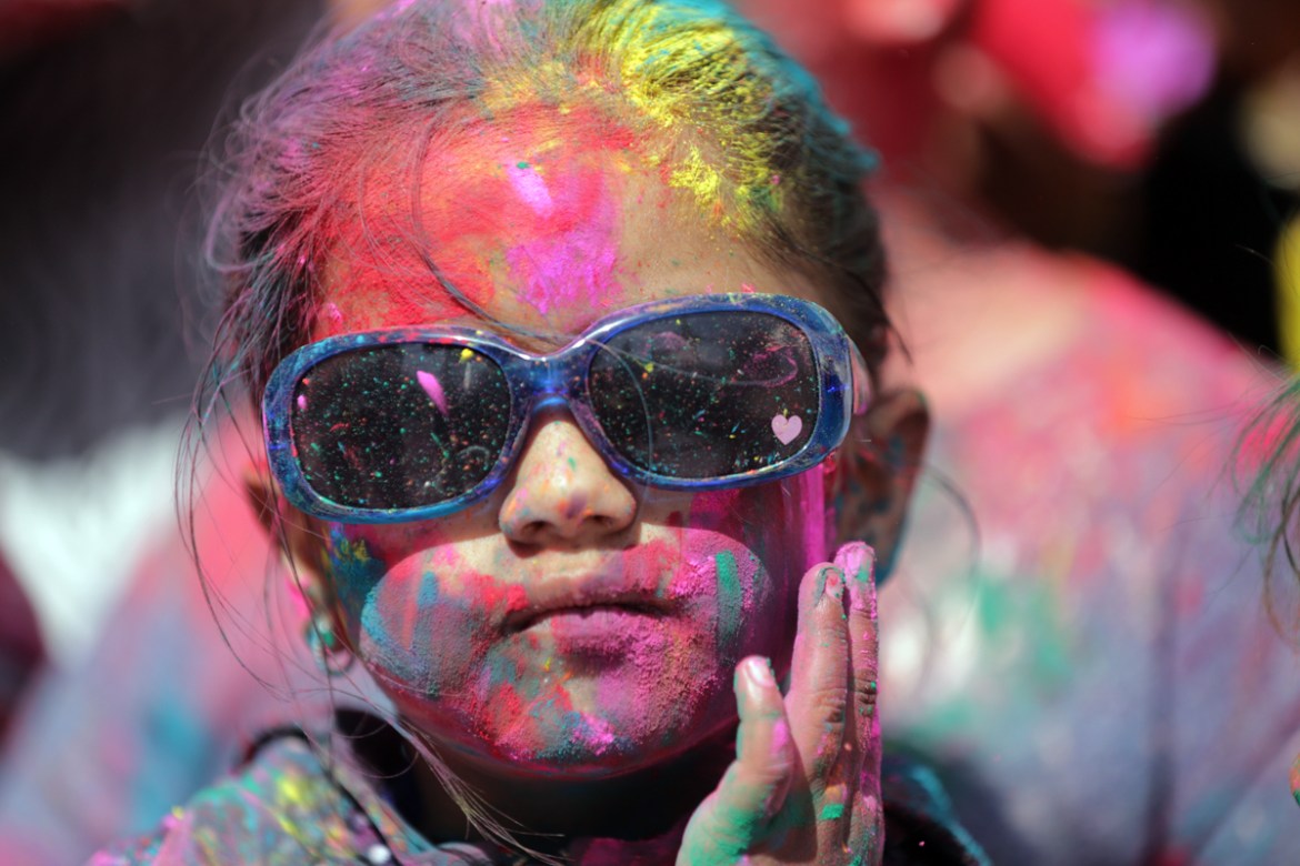 A young girl smeared with powdered colors takes part in Holi festival celebrations at Durgiana Temple in Amritsar, India, 20 March 2019. Holi is observed at the end of the winter season on the last fu