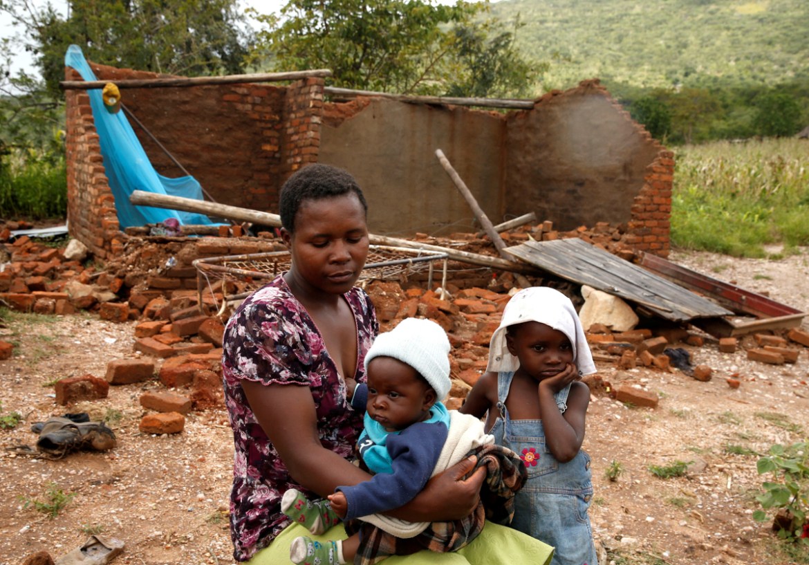Nomatter Ncube and her kids sit beside their washed away family home following Cyclone Idai in Chimanimani district, Zimbabwe, March 18, 2019. REUTERS/Philimon Bulawayo