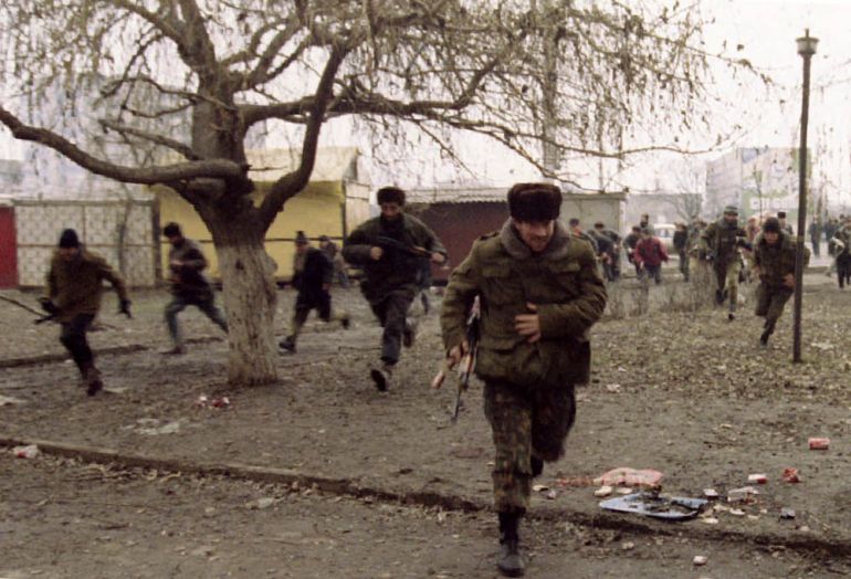 Chechen fighters run to take cover as they hear warplanes flying overhead during an artillery and rocket attack in the center of the Chechen capital, January 9, 1995. REUTERS/Yannis Behrakis/File phot