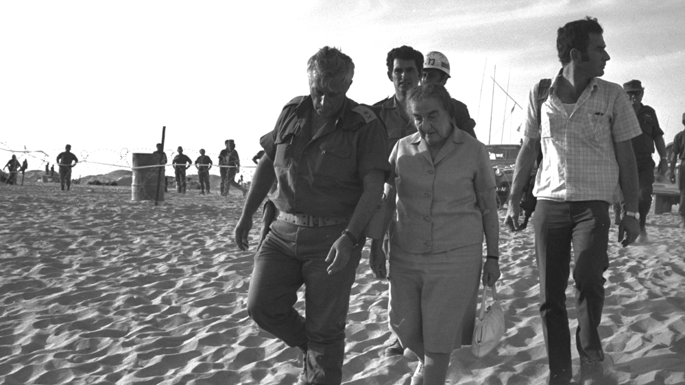 Meir, right, is escorted by Israeli Major General in the Reserves Ariel Sharon, left, while visiting the Sinai Peninsula, then occupied by Israel, October 29, 1973 [File: Yehuda Tzion/Government Press Office/Handout/Reuters]