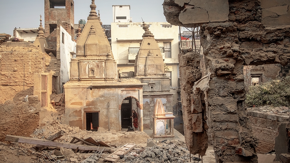 A woman visits a temple recently surfaced from the rubble. Some 55 temples and places of worship have been found in the area acquired by the government [Andrea de Franciscis/Al Jazeera]
