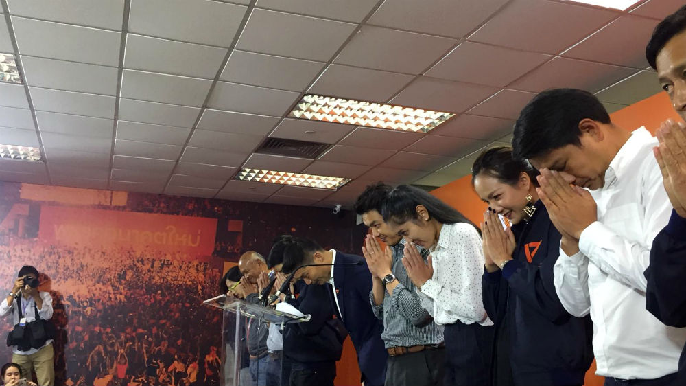 Thanathorn Juangroongruangkit and other Future Forward party leaders bow to the media after a press conference in Bangkok on Monday [Hathairat Phaholtap/Al Jazeera]
