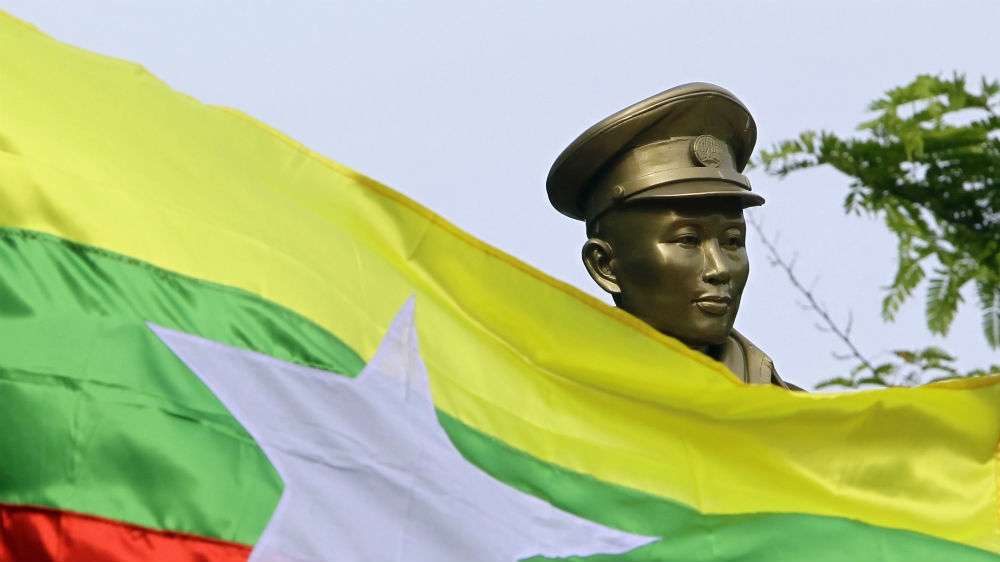 The Myanmar national flag flies in front of a statue of General Aung San during a ceremony marking the 70th anniversary of his 1947 assassination [Aung Shine Oo/AP]