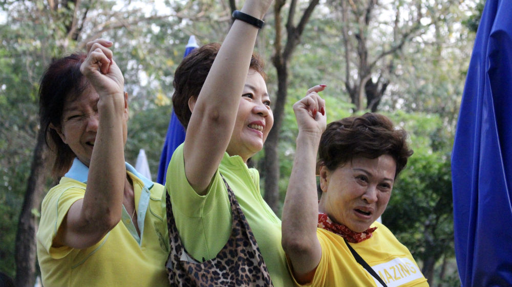 Women in Bangkok cheer for Prayuth during an appearance on Tuesday [Kate Mayberry/Al Jazeera]