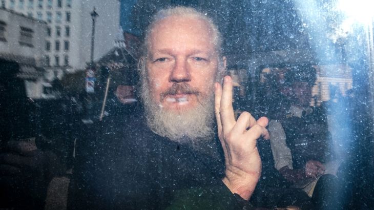Julian Assange gestures to the media from a police vehicle on his arrival at Westminster Magistrates court on April 11, 2019 in London, England. After weeks of speculation Wikileaks founder Julian Ass