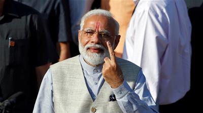 Modi shows his ink-marked finger after casting his vote in Ahmedabad [Amit Dave/Reuters]